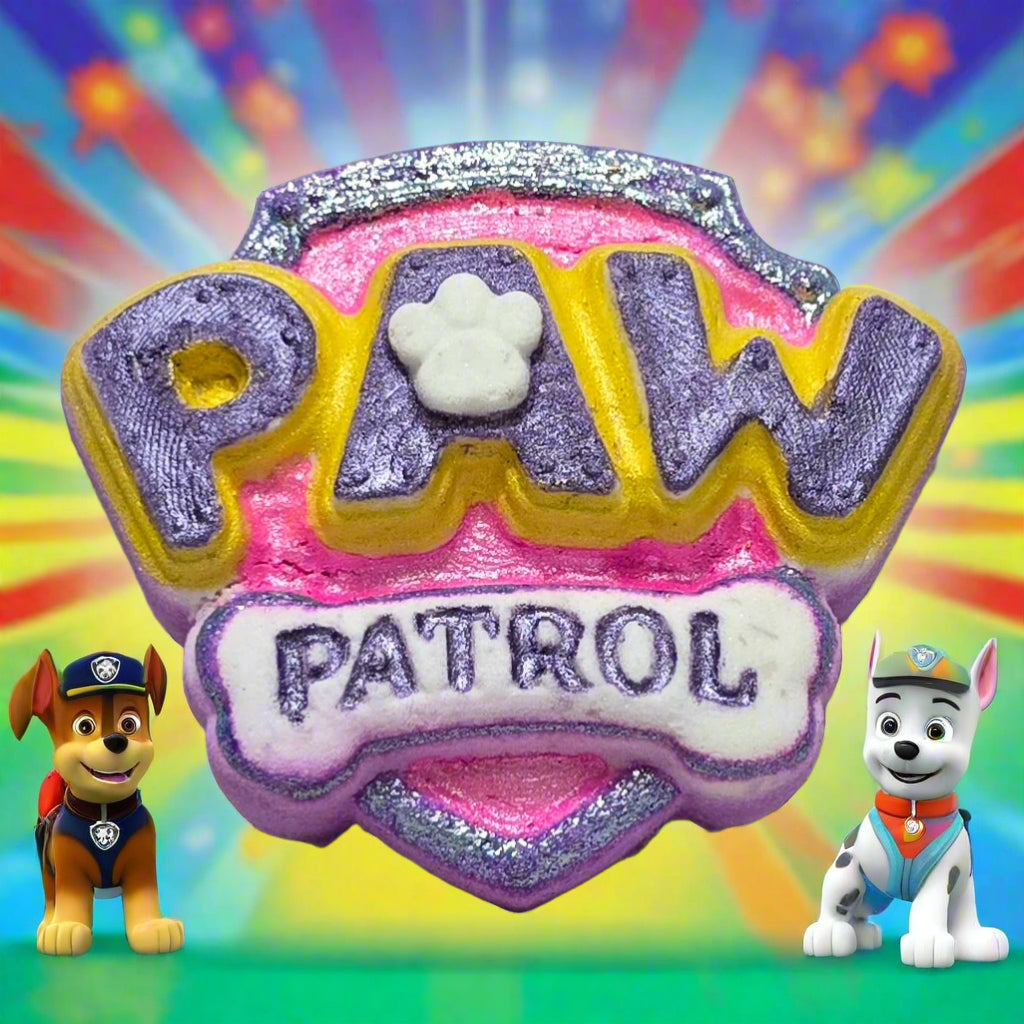 Topher’s Beard and Soap Co. Pink and Purple Paw Patrol Bath Bomb – hand-painted bath bomb shaped like the Paw Patrol logo in pink and purple, displayed on a pastel tile surface with playful bath props and bubbly accents.