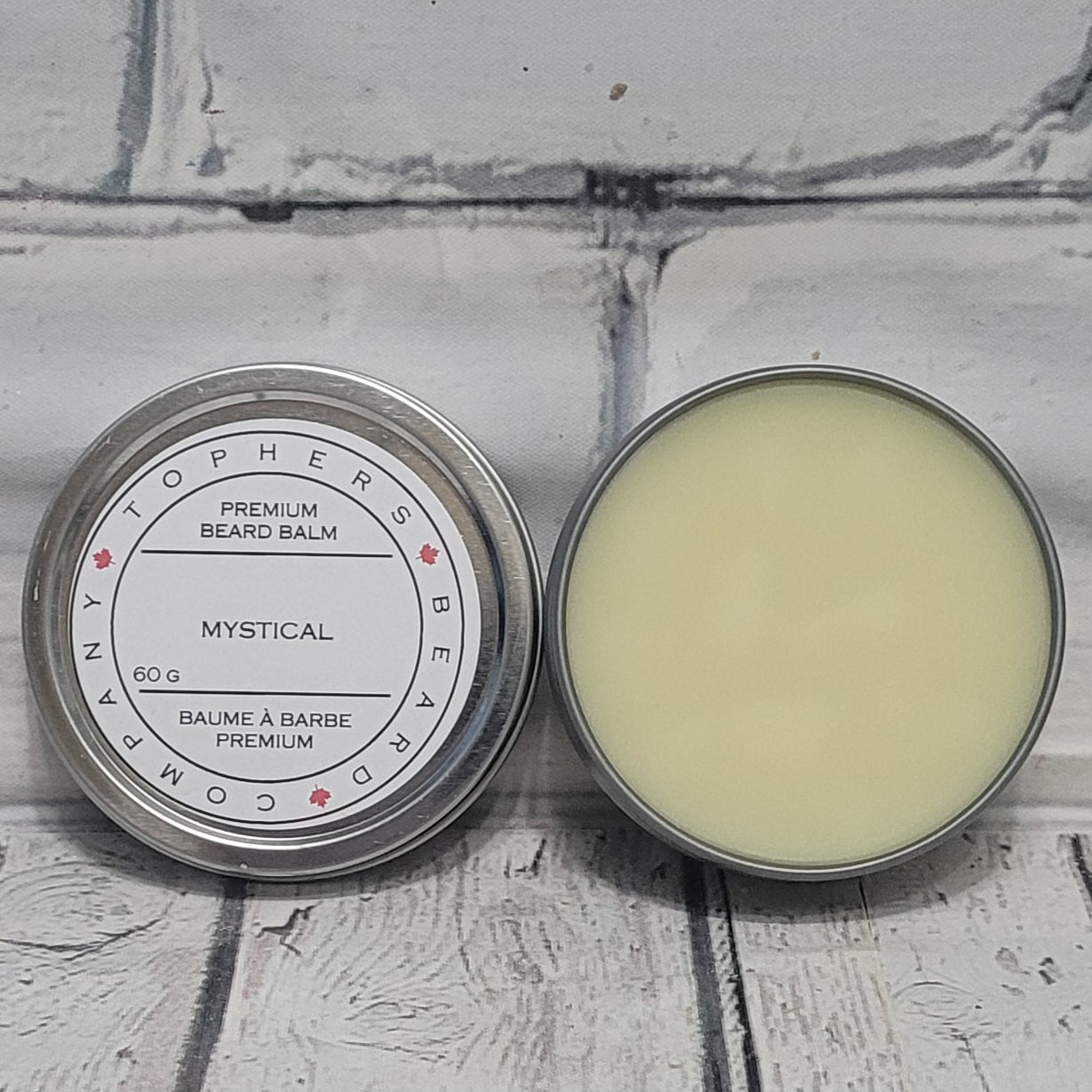 Topher's Beard and Soap Co. Mystical Beard Balm – 60 g tin shown open and closed on rustic white wood background, highlighting creamy texture and clean, minimalist label design