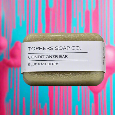 "Topher's Beard and Soap Co. Blue Raspberry Conditioner Bar – solid 58 g bar with minimalist label, displayed against a vibrant blue and pink dripping background for a bold, fun aesthetic