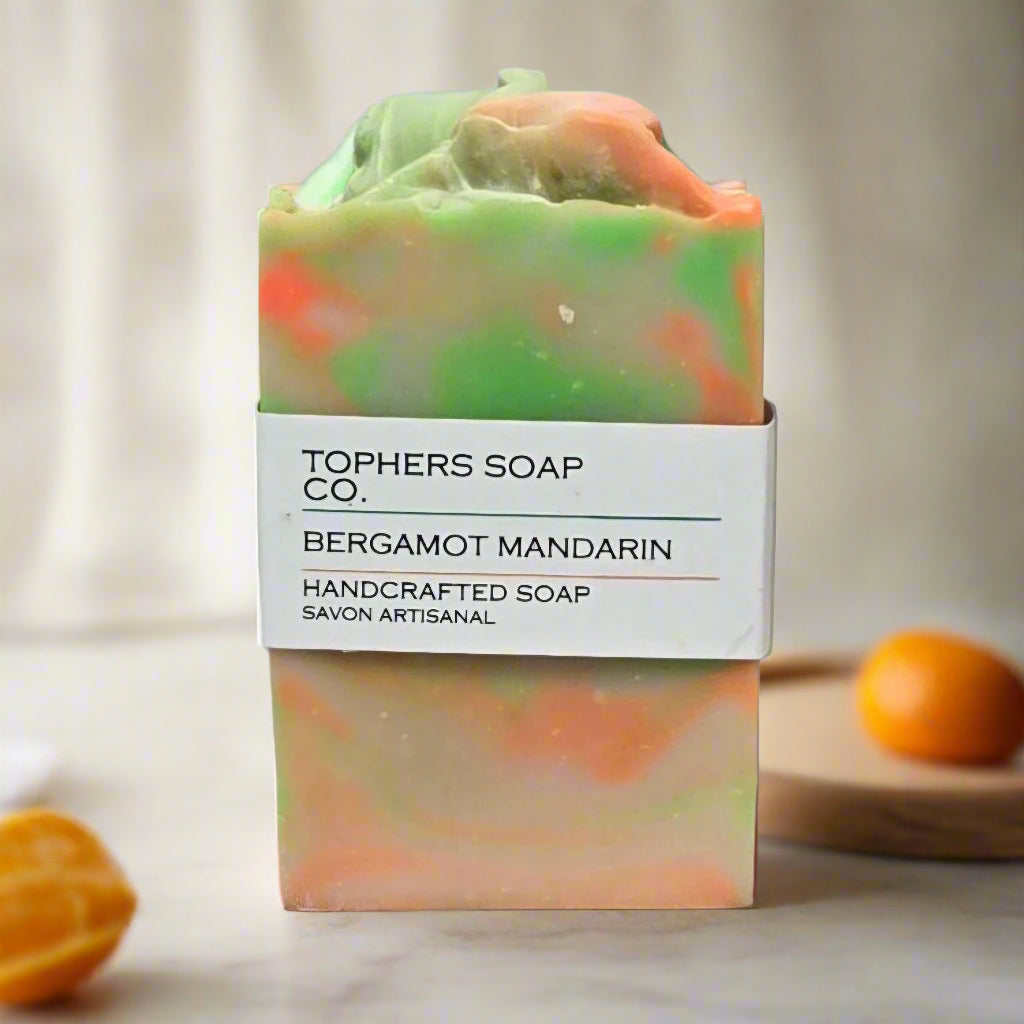 Topher's Beard and Soap Co. Bergamot Mandarin Handcrafted Soap – citrus-colored soap bar with swirls of orange, green, and cream, labeled and displayed with fresh mandarins on a light, natural background