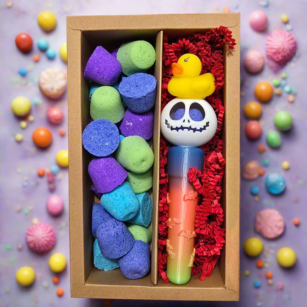 Topher's Beard and Soap Co. bath gift set – boxed collection featuring rainbow mini bath bombs, Jack Skellington-inspired bath bomb with a rubber duck topper, and a rainbow drip bath bomb stick, surrounded by colorful candy-style decor