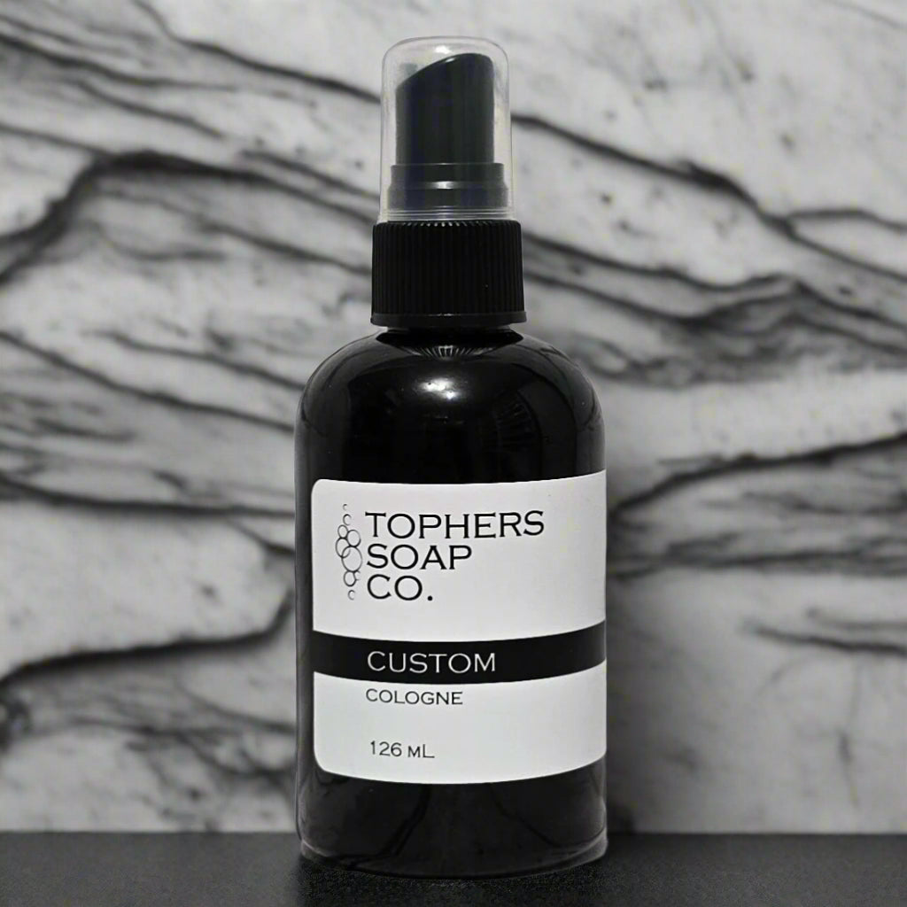 Topher’s Beard and Soap Co. Custom Cologne – 126 ml black cologne bottle with a minimalist label, displayed in front of a white and gray marble backdrop to emphasize premium quality and personalization.