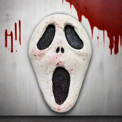 Topher’s Beard and Soap Co. Ghostface Bath Bomb – hand-painted horror-themed bath bomb inspired by the Scream movie franchise, featuring the iconic white mask with black details and blood splatter, styled against a blood-streaked wall with the word “Hi” written in dripping red.