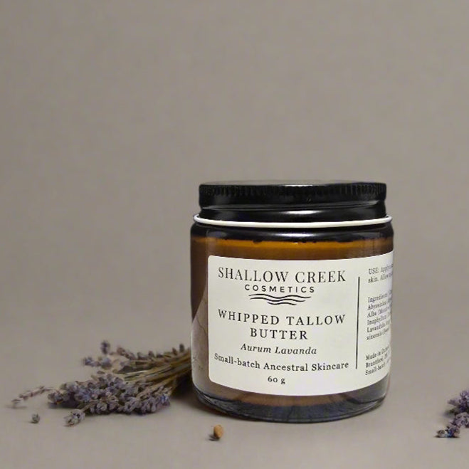 Shallow Creek Cosmetics Whipped Tallow Butter in Aurum Lavanda scent, a 60g jar. The product is presented with dried lavender sprigs, highlighting its natural ingredients.