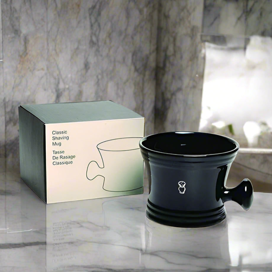 Topher's Beard and Soap Co. Classic Shaving Mug – glossy black ceramic shaving mug with ergonomic handle, paired with minimalist retail box, displayed on a marble countertop in a luxurious bathroom setting