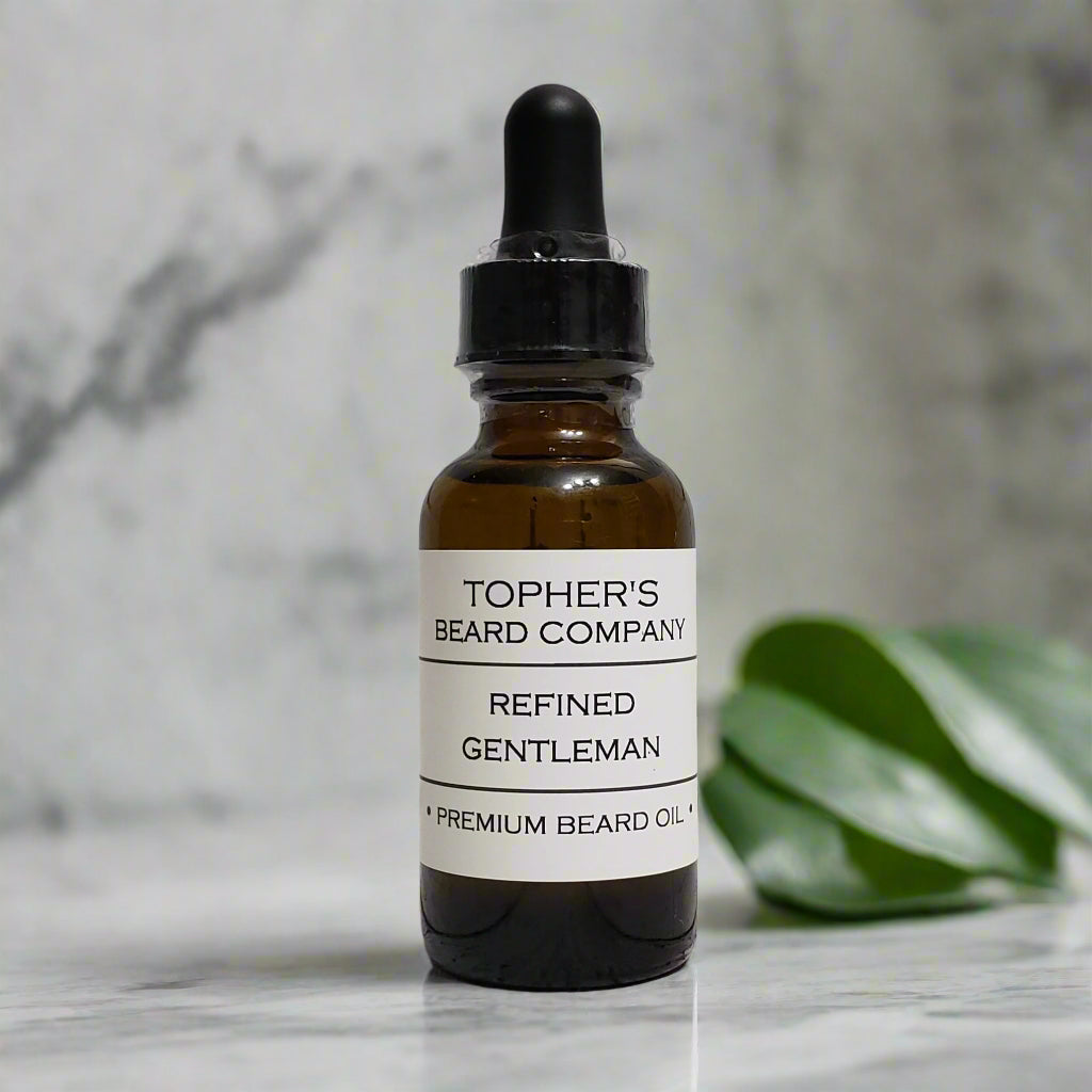 Refined Gentleman beard oil bottle on a bathroom marble counter with greenery in the background – a bold and sophisticated scent by Topher’s.
