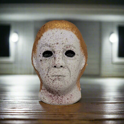 A collectible bath bomb featuring the recognizable mask of Michael Myers, showcasing the hand-painted details for a fun and eerie bath. Made in Brantford, Canada.