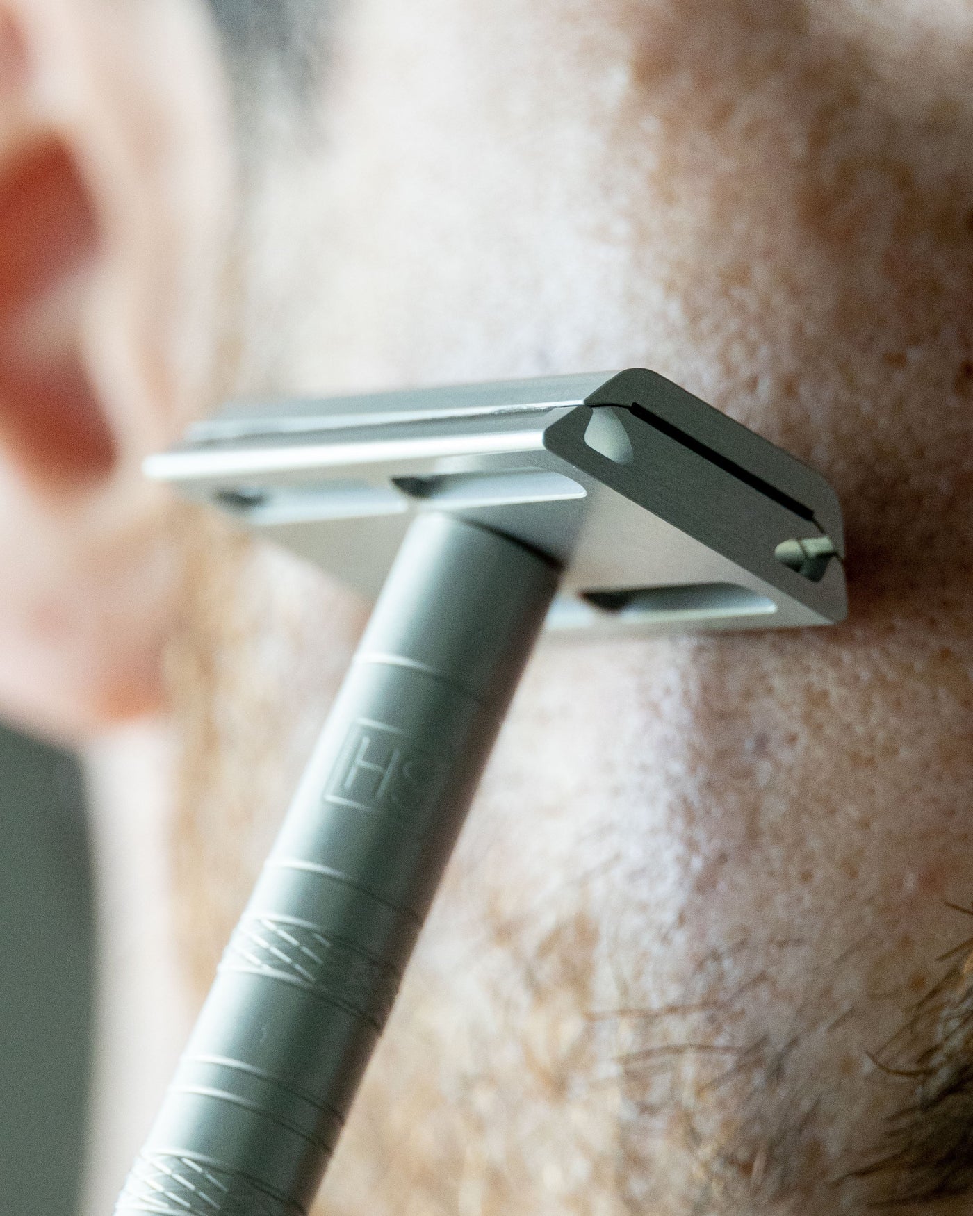 Close-up of the Henson AL13 Safety Razor against skin during shaving - Get yours at Tophers Beard and Soap Co.